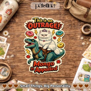 May include: A sticker featuring a white cat wearing a crown riding a green dinosaur, with the text "This is an OUTRAGE!" and "Mongo is Appalled." The design includes donuts and lightning bolts, with the phrase "Small Things, Big Personality."