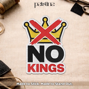 May include: Embroidered patch featuring a yellow crown crossed out with a red "X". The words "NO KINGS" are below the crown in black and red. The patch has a white border and the text "Made to Stick. Made to Stand Out."