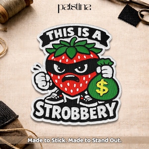 May include: Embroidered patch featuring a red strawberry with a black eye mask, holding a green money bag with a dollar sign. The patch reads "THIS IS A STROBBERY" and "Made to Stick. Made to Stand Out."