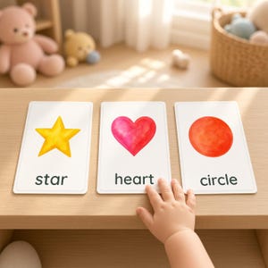 May include: Three rectangular white educational flashcards featuring watercolour illustrations of a yellow star, a red heart, and a red circle, with the corresponding black text labels star, heart, and circle printed below each shape.
