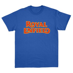 May include: A royal blue short-sleeve t-shirt featuring the text ROYAL ENFIELD printed in a bold, stylized font across the chest. The lettering is red with a thin yellow outline, creating a high-contrast graphic design on the solid blue fabric.