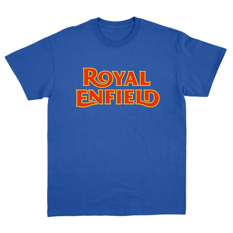 May include: A royal blue short-sleeve t-shirt featuring the text ROYAL ENFIELD printed in a bold, stylized font across the chest. The lettering is red with a thin yellow outline, creating a high-contrast graphic design on the solid blue fabric.
