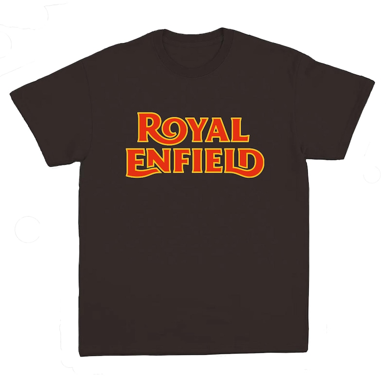 May include: A dark brown short-sleeved t-shirt featuring the text ROYAL ENFIELD printed in a bold, stylized font across the chest. The lettering is red with a bright yellow outline, creating a high-contrast graphic design on the solid fabric.