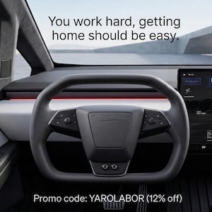 May include: The interior of a vehicle featuring a dark gray yoke-style steering wheel, a white dashboard with a red accent light, and a large digital display screen showing a Labor Day Sale and a white truck. Text reads: You work hard, getting home should be easy. Promo code: YAROLABOR (12% off).