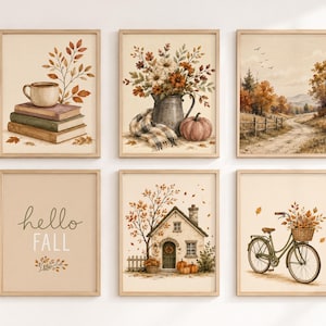 Può includere: Un set di sei stampe artistiche da parete incorniciate con temi autunnali: una tazza su libri, un vaso di fiori con una zucca, un paesaggio rurale, il testo "hello FALL", un cottage con zucche e una bicicletta con un cesto di foglie.