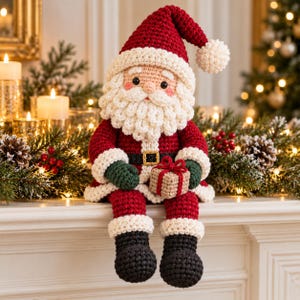 May include: A crocheted Santa Claus doll featuring a red hat with a white pom-pom, a thick white beard, a red coat with a black belt and gold buckle, dark green mittens, and black boots. The doll holds a small tan gift box with a red ribbon.