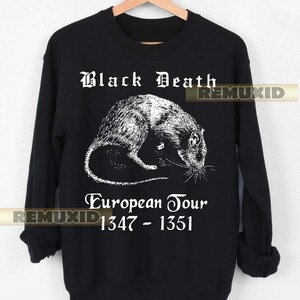 Puede incluir: Sudadera negra con un diseño blanco de una rata y el texto "Black Death European Tour 1347-1351". El diseño tiene un estilo vintage.