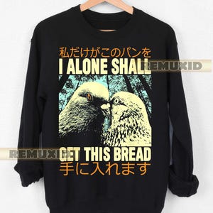 May include: Black sweatshirt with a graphic of two pigeons facing each other. The text "I ALONE SHALL GET THIS BREAD" is printed in yellow and white. Japanese text is also present.