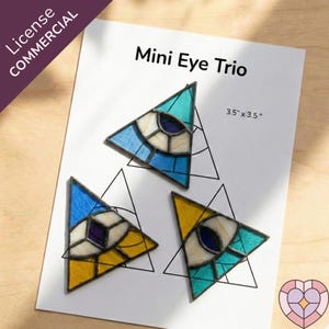 May include: A trio of stained glass eye designs in triangular shapes. Each eye features a different color scheme: blue and white, yellow and white, and teal and white. The text "Mini Eye Trio" is displayed above the designs. Each piece is 3.5 x 3.5 inches.