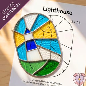 Op de afbeelding: Een glas-in-lood vuurtorenontwerp met blauwe, gele, witte en groene glazen stukken. Het ontwerp staat op een wit papier met de tekst "Lighthouse" en "5 x 7.5". Het ontwerp is omgeven door een zilveren metalen frame.