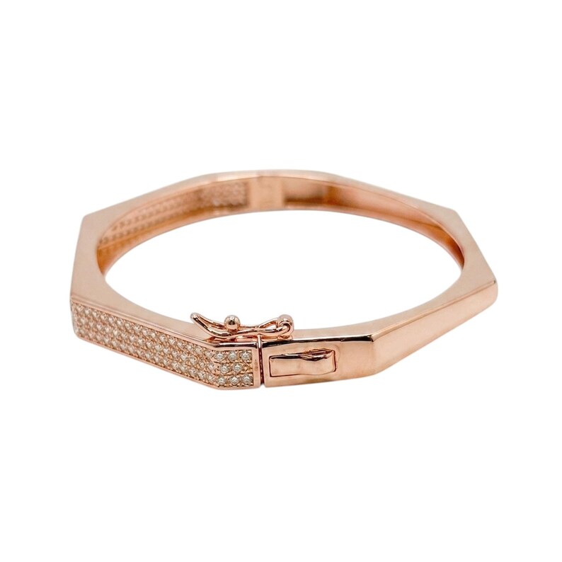 Pode incluir: Pulseira em tom de ouro rosa com um design geom&eacute;trico. A pulseira apresenta um fecho retangular e uma se&ccedil;&atilde;o incrustada com pequenas pedras preciosas transparentes. A pulseira foi projetada para ser usada ao redor do pulso.