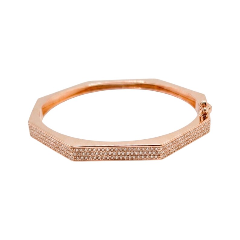 Pode incluir: Pulseira de bracelete em tom de ouro rosa com um design geom&eacute;trico octogonal. A pulseira &eacute; incrustada com pequenos cristais brilhantes ao longo das bordas. O fecho &eacute; vis&iacute;vel no lado direito. Joalharia.