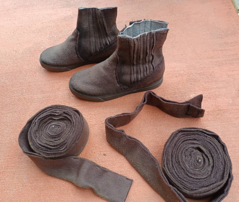 May include: Two pairs of brown felt boots with a fold-over top and a pair of brown felt boot straps.