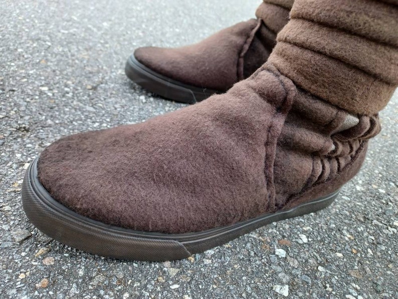 May include: Brown suede ankle boots with a fold-over cuff and a black rubber sole.