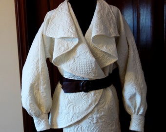 Quilted jacket ivory wrap coat belted asymmetric draped collar long sleeves cuffs futuristic star wars brown leather belt