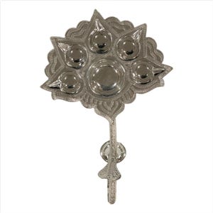 May include: A silver-colored, ornate metal object with a leaf-like design. It features multiple circular indentations, possibly for holding items, and a long handle. The intricate details and polished finish suggest a decorative or ceremonial purpose.