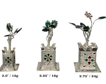 May include: Three silver-colored metal Tulsi plant sculptures with green and red enamel accents. The bases are square with floral patterns. Heights and weights are labeled as 2.0 inches/12g, 2.25 inches/16g, and 2.75 inches/24g respectively.