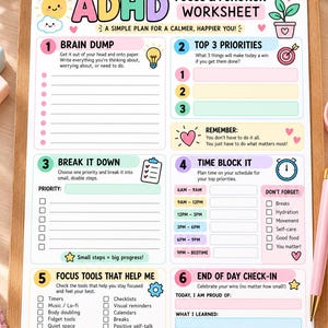 Può includere: Un foglio di lavoro ADHD focus & function su una cartellina con clip rosa. La pagina colorata presenta sezioni per brain dump, 3 priorità, suddivisione dei compiti, blocchi temporali, strumenti di concentrazione e un riepilogo giornaliero.