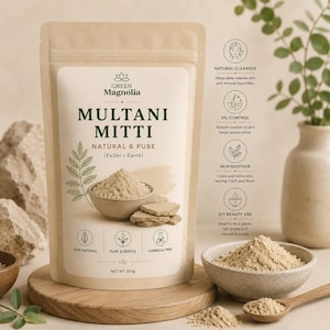 May include: A beige stand-up pouch of Green Magnolia Multani Mitti Fuller's Earth powder. The label features a bowl of powder, text, and icons. Below the pouch, a wooden bowl contains the powder, with a wooden spoon nearby. Net weight 200g.