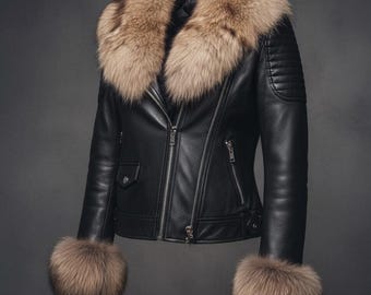 Puede incluir: Chaqueta de cuero negra con cuello y puños de piel. La chaqueta presenta un estilo motero clásico con cierre de cremallera y detalles acolchados en los hombros. El ribete de piel es de color marrón claro.