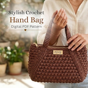 May include: A brown crochet handbag featuring a textured stitch pattern, two top handles, and a gold-tone zip closure. A rectangular gold-tone plaque with the text Versace Jeans Couture is attached to the front. The image includes the text Stylish Crochet Hand Bag Digital PDF Pattern.