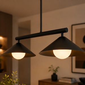 Op de afbeelding: Een moderne zwarte hanglamp met twee conische kappen. Elke kap heeft een witte, bolvormige gloeilamp. De lamp hangt aan het plafond en creëert een eigentijds verlichtingsontwerp.