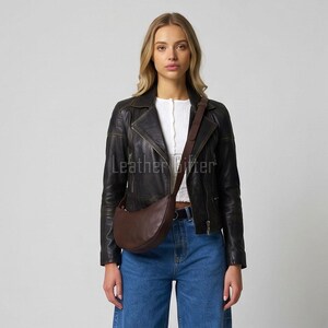 May include: A dark brown leather crescent-shaped crossbody bag with a matching adjustable shoulder strap. The bag features a smooth, curved silhouette and is worn across the torso. The text Leather Gifter is visible in the center of the image.