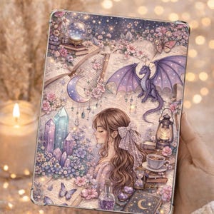 Könnte beinhalten: Eine Tablet-Hülle mit einer Fantasy-Illustration, die einen Drachen, Kristalle und eine Frau zeigt. Das Design umfasst einen Sternenhimmel, Blumen und offene Bücher. Die Farbpalette ist sanft, mit Lila, Rosa und Blau. Der Text "DesignByM Andrew" ist sichtbar.