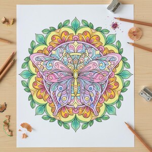 May include: A detailed butterfly coloring page with a mandala design. The butterfly is colored in shades of pink, blue, and yellow, with intricate patterns. Surrounding the butterfly is a circular mandala with green, yellow, and orange hues. Pencils and sharpeners are scattered around the page.