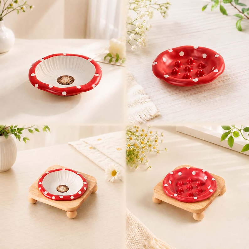 May include: A set of ceramic mushroom-shaped dishes featuring a red cap with white polka dots. Two dishes are shown, one with a white interior and one with a red interior featuring raised bumps, both displayed alone and on small wooden stands.