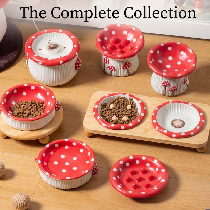 May include: A collection of ceramic pet bowls and feeders featuring red and white mushroom designs with polka dots. The set includes various bowl shapes, some with raised textures, and a rectangular wooden stand holding two bowls filled with kibble.