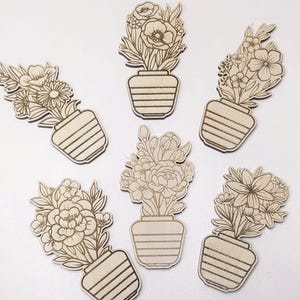 Könnte beinhalten: Sechs Holz-Blumen-Ausschnitte. Jeder Ausschnitt zeigt eine andere Anordnung von Blumen in einer Vase. Die Vasen haben ein gestreiftes Design. Die Blumen und Vasen sind in Naturholzfarbe gehalten.