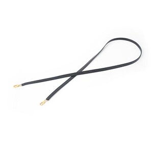 May include: A black, thin strap with gold-colored clasps on each end. The strap is designed to be used as a replacement or accessory for a handbag or purse. The strap is shown against a white background.
