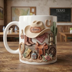 Peut inclure: Mug en céramique blanche avec un motif détaillé sur le thème du Far West. Comprend un chapeau de cowboy avec le nom "Anna", des bottes de cowboy, un fer à cheval, un cactus et une selle. Le mug est posé sur une table en bois, avec un arrière-plan sur le thème du Texas.