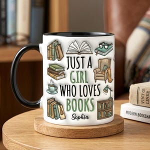 Pu&ograve; includere: Tazza in ceramica bianca con manico e bordo neri, con la scritta "Just a Girl Who Loves Books" in verde, insieme a illustrazioni di libri, occhiali e una poltrona da lettura. Il nome "Sophia" &egrave; stampato sotto.