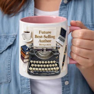 May include: White ceramic mug with a pink interior and handle. The mug features a vintage typewriter, a stack of books, a coffee cup, a laptop, and a pen. The text on the mug reads "Future Best-Selling Author" and "Benjamin".