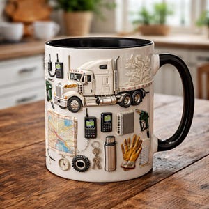 May include: White ceramic mug with a black interior and handle, featuring a 3D relief design of a semi-truck, map, and various trucker-related items. The mug has a detailed design and is set on a wooden surface.