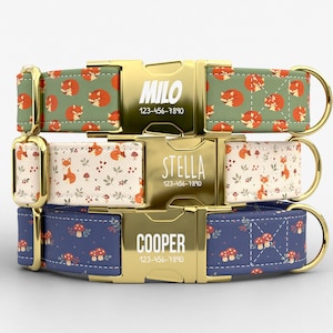 May include: Three personalized dog collars with gold-colored buckles. The top collar has a green background with orange foxes. The middle collar has a cream background with foxes and leaves. The bottom collar has a blue background with mushrooms. Each collar has a name and phone number.