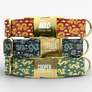 May include: Three personalized dog collars with gold-colored buckles and hardware. The collars feature dragon patterns in red, navy blue, and green. Each buckle is engraved with a name and phone number.