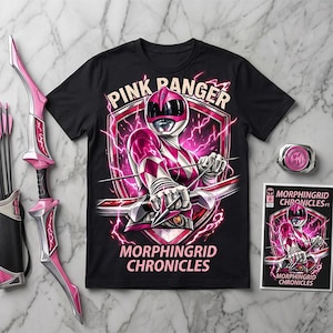 Può includere: T-shirt nera con grafica Pink Ranger di Morphingrid Chronicles. Il design include un Power Ranger rosa e bianco con arco e frecce, un fumetto e una fibbia rosa. È visibile anche un set di arco e frecce rosa.
