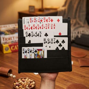 May include: A black fabric playing card holder with multiple horizontal slots, displaying a variety of playing cards including diamonds, clubs, and face cards. The holder is designed to organize and display cards during games.