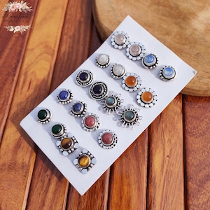 Wholesale mix gemstone stud earrings displayed on card, featuring assorted natural stones including moonstone, labradorite, amethyst, lapis lazuli, tiger eye, green onyx and carnelian. Handmade silver plated stud earrings with brass base metal, mixed designs and shapes. Bulk gemstone stud earrings for jewelry resellers, boutiques, birthstone collections, boho jewelry shops, crystal lovers and wholesale jewelry supply businesses.