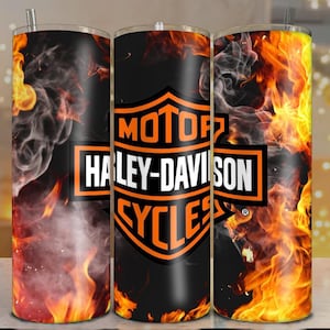 May include: A stainless steel tumbler featuring the Harley-Davidson Cycles logo in orange and white against a black background. The design includes flames and smoke effects in shades of orange, yellow, and red.