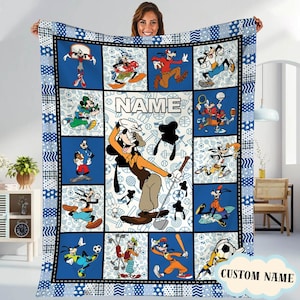 Könnte beinhalten: Eine blau-weiß karierte Decke mit Cartoon-Charakteren in verschiedenen Sportposen. Die Decke hat einen schwarzen Rand und einen blau gemusterten Rand. Das Wort "NAME" ist auf die Decke gedruckt, mit einem "CUSTOM NAME"-Tag in der Ecke.