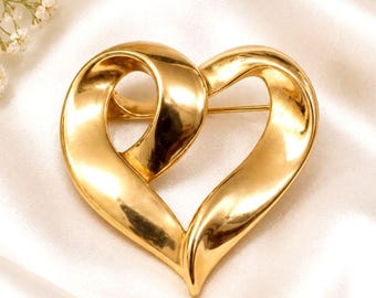 Broche vintage dourado em formato de coração com laço, joia marcante.