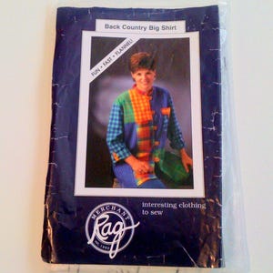 May include: A sewing pattern for a "Back Country Big Shirt" in a plastic sleeve. The pattern features a colorful flannel shirt with patchwork design. The packaging includes the text "FUN * FAST * FLANNEL!" and the Rag Merchant logo.