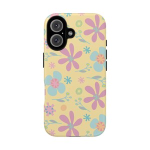 Puede incluir: Una funda de teléfono con un estampado floral. La funda tiene un fondo amarillo claro con un patrón repetido de flores rosas, azules y amarillas y hojas verdes. La funda del teléfono tiene una cámara negra y botones laterales negros.