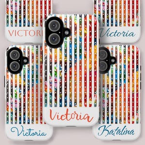 Puede incluir: Varias fundas de teléfono con un vibrante patrón abstracto. Las fundas muestran rayas verticales en rojo, naranja, azul y blanco, con una base blanca. Algunas fundas tienen los nombres "Victoria" y "Katalina" en cursiva.