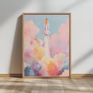 May include: A framed art print showing a space shuttle ascending through vibrant, pastel-hued clouds. The shuttle is white with orange detailing, and the clouds are a blend of pink, yellow, blue, and purple. The artwork is set against a light blue sky.