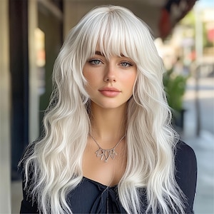 May include: A set of three ceramic mugs with a speckled, cream-colored glaze. Each mug features a different hand-painted floral design in shades of blue, green, and yellow. The mugs have a simple, modern shape.